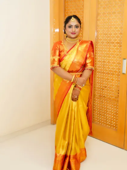 This look is all about festive radiance. The client is glowing in her yellow and red silk saree, with makeup that features a flawless base, defined eyes, and a classic red lip perfect for any traditional celebration.