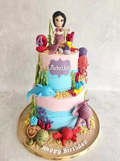 A colourful underwater world for Advika's 4th birthday. This two-tiered cake is covered in friendly sea creatures like dolphins, octopuses, and turtles, all handmade from fondant.