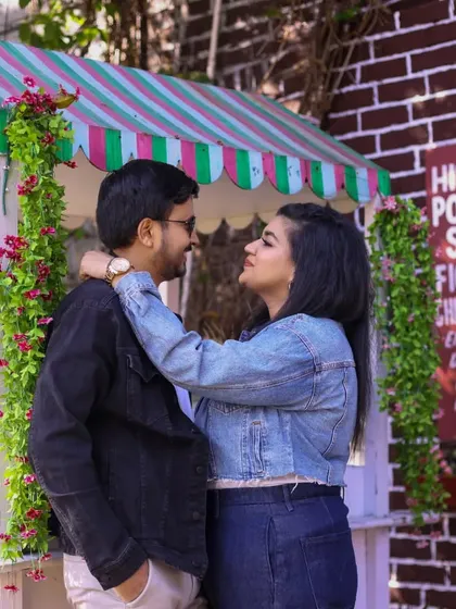 A sweet, interactive moment from a pre-wedding shoot at a small, market-style stall, showcasing the couple's connection.