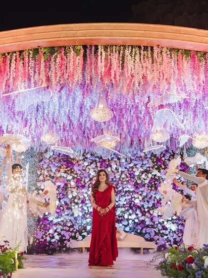 A wide shot of the bride's stunning reception entry. The ceiling was covered in hanging wisteria, creating a magical, dreamlike canopy.