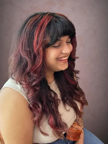 A rock chick shag haircut with red accents for Amrapali. This cut is full of texture and personality.