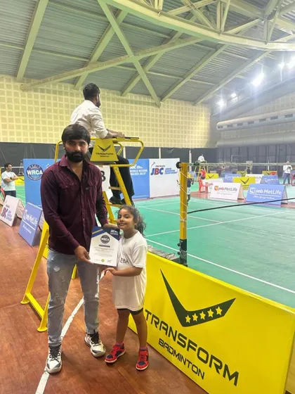 A proud moment as one of our youngest champions receives her certificate at a PNB MetLife Junior Badminton Championship event.