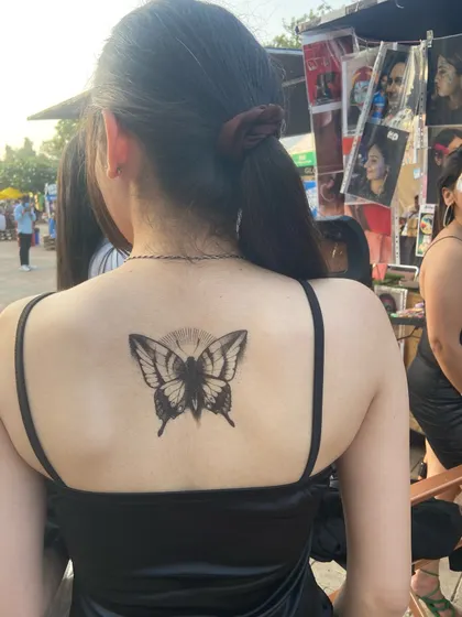 Temporary tattoos are also a big part of what I do. This black butterfly on the back is a simple, elegant, and bold statement.