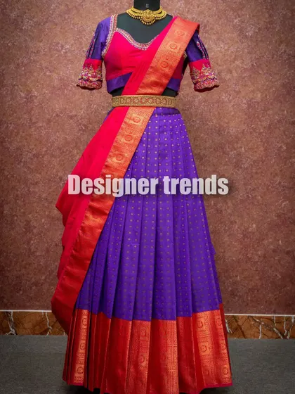 A classic pattu langa voni in purple and red with a gold border, paired with a puff-sleeve blouse featuring embroidery on the cuffs.