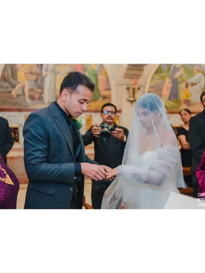 The ring exchange, a close-up shot capturing the groom placing the wedding band on the bride's finger.