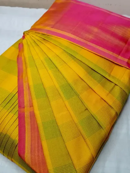 A bright yellow and pink checked saree, pleated and ready to wear. My service makes even everyday sarees look special.