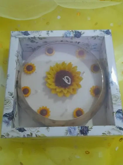 Bring sunshine to your celebrations with our sunflower cake candle. It features a large sunflower on top with smaller ones around the edge, perfect for birthdays and special moments.