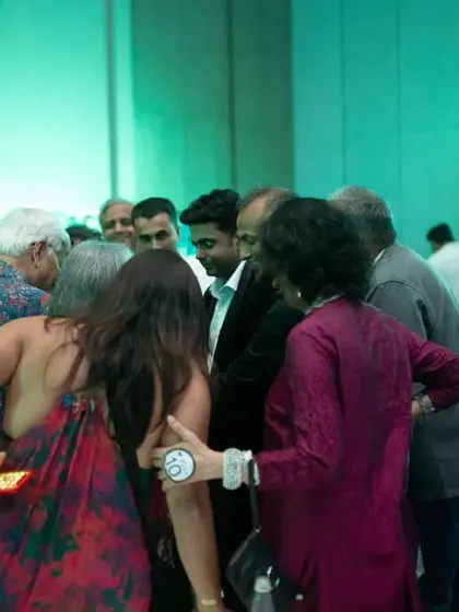A group of guests huddle together, completely absorbed in the close-up magic happening in front of them. It's all about creating an intimate and captivating experience.