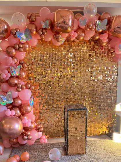 A close-up of the detailed balloon work, featuring different sizes and shades of pink and rose gold against the sequin wall.