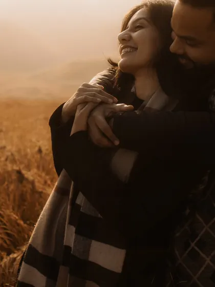 A warm and joyful embrace in a field of gold. The soft, hazy light and the bride's happy expression make this an incredibly heartwarming and candid portrait.