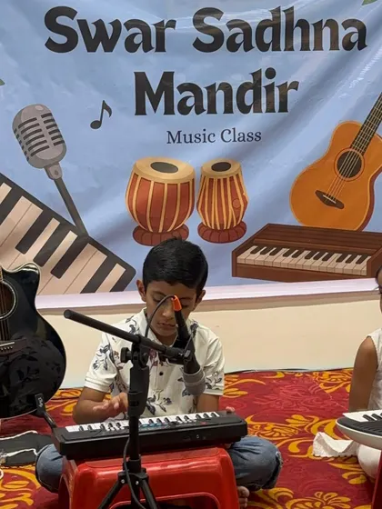 A young boy sings into the microphone while playing his keyboard. We encourage students to explore both instrumental and vocal skills, helping them become well-rounded musicians.