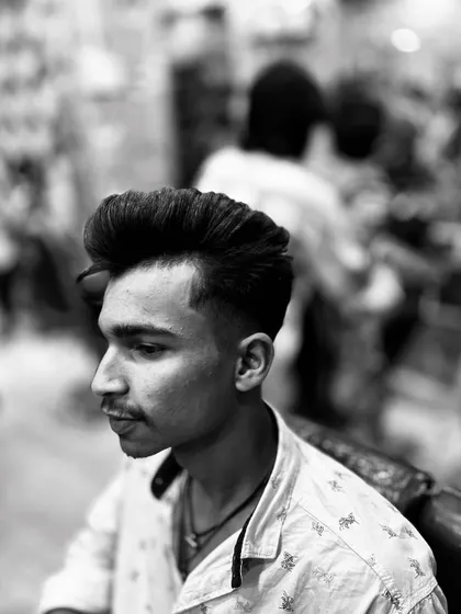 This black and white photo emphasizes the clean lines of this fade haircut. The focus is on the seamless blend and the sharp temple lineup.
