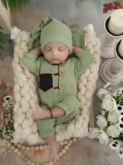 A relaxed and natural pose of a sleeping newborn. This top-down shot captures the baby's peaceful slumber in a beautifully styled, comfortable setting.