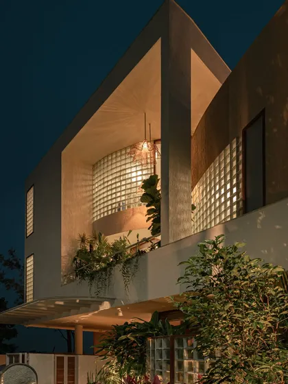 This series of images shows how the home's exterior transforms from day to night. The glass block walls, which provide privacy during the day, become luminous features in the evening, creating a warm and inviting aura.