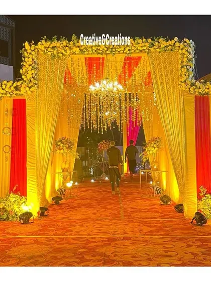 A vibrant entrance with red and yellow striped draping. The warm lighting and floral borders create a cheerful and traditional welcome for guests.