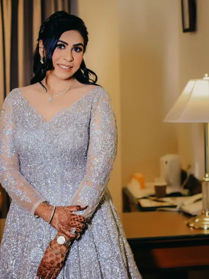 A classic portrait of the bride in her shimmering silver gown. The soft lighting and her gentle smile create a timeless and elegant image.