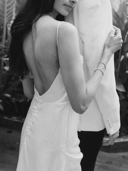 An intimate black and white close up focusing on the elegant back of Khushali's dress as she holds onto Sahil.