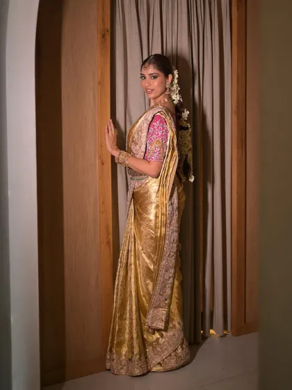 A full-length shot showing the magnificent drape of the golden Kanjeevaram saree. The makeup is designed to complement the grandeur of the entire ensemble.