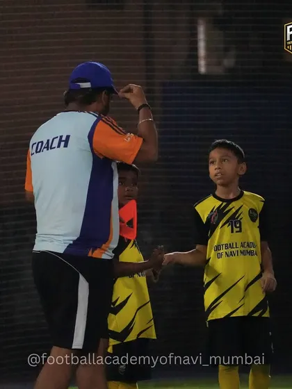 A coach shares a moment of encouragement with a young player. These small interactions build trust and confidence.