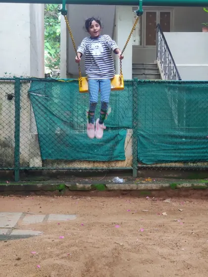 A child enjoys the simple freedom of flying high on a swing at our neighborhood park. We believe in utilizing these public spaces for play and community building.