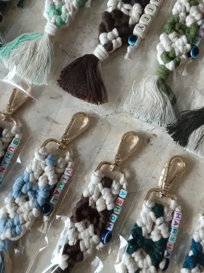 Here is a collection of personalized keychains ready for dispatch. You can see the different color combinations and names like 'Suhani', 'Vimal', and 'Ashok', each with a protective evil eye bead.