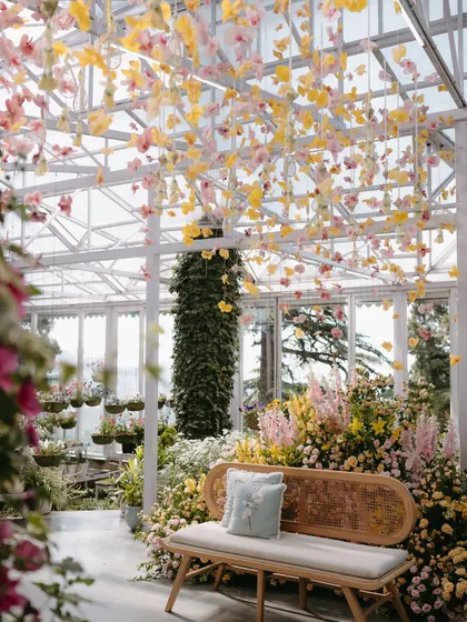 A beautiful shot of the seating area, with a canopy of hanging yellow and pink orchids. The design was meant to feel like being inside a blooming garden.