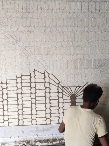 A craftsman working on the intricate pattern of a custom rug. We collaborate with talented artisans to bring our unique designs to life.