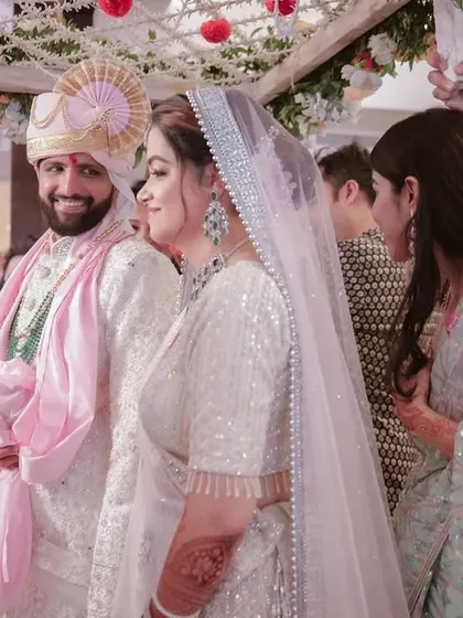 A side profile of the couple during their wedding ceremony, capturing the groom's happy expression as he looks towards his bride.