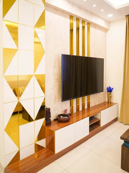 This entertainment center features a bold geometric partition with gold mirror inlays, creating a glamorous and modern focal point in the living room.