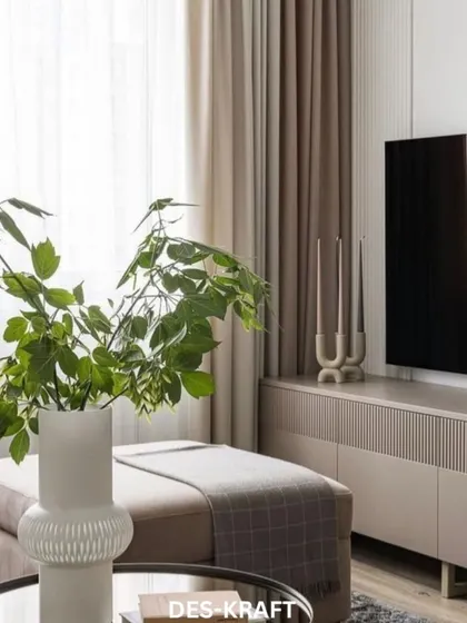 A close-up of the entertainment console and decor, where natural elements like the green plant contrast beautifully with the room's minimalist and modern aesthetic.