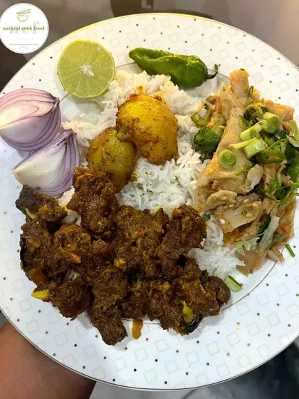 A flavourful combination of buff stir fry and bamboo shoot eromba, served with rice and fresh garnishes.