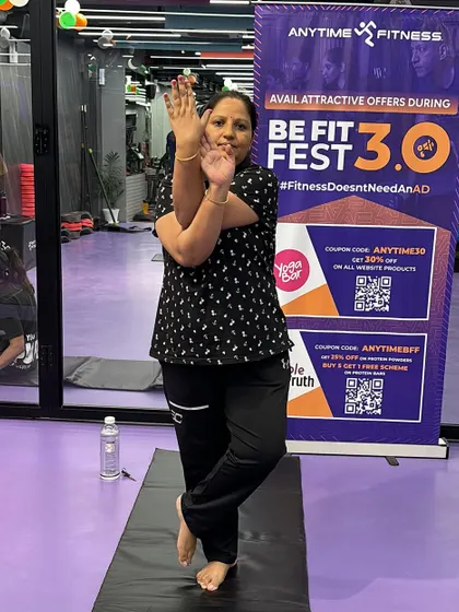 A participant smiles while holding the Eagle Pose, capturing the positive and encouraging vibe of our community events.