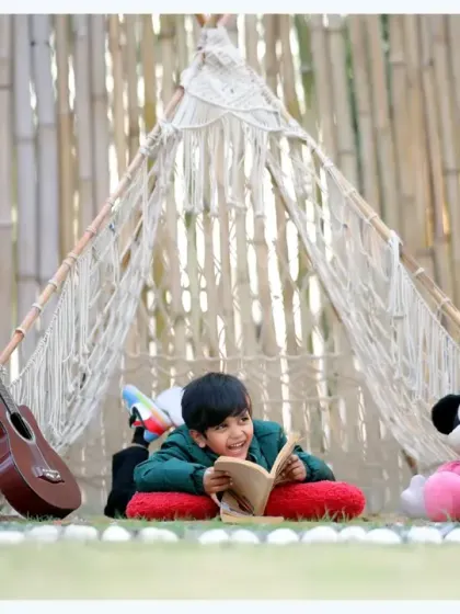 A cozy and imaginative reading moment in our outdoor teepee setup, complete with a guitar and a Mickey Mouse plush toy.