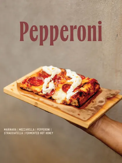 A spicy and sweet Pepperoni slice from our Romana menu, topped with stracciatella and fermented hot honey.