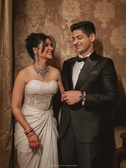 A classic portrait that radiates elegance. The groom's smart tuxedo and the bride's modern white gown create a beautiful contrast, perfect for a sophisticated reception look.