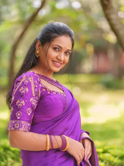 A happy close-up of the model, showcasing the fine craftsmanship of the designer blouse available for rent.