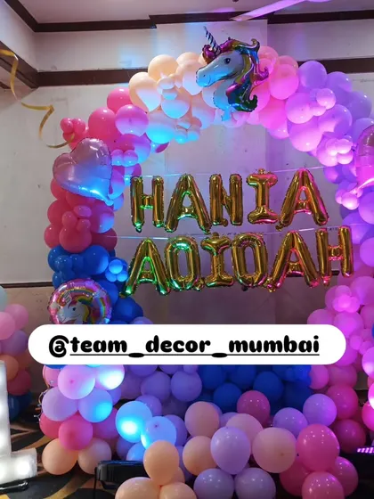 A full shot of the unicorn first birthday setup, showing the marquee number, balloon arch, and themed foil balloons.