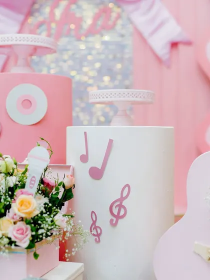 Details from the dance party, including music note cutouts, a mini microphone, and a pink guitar prop.