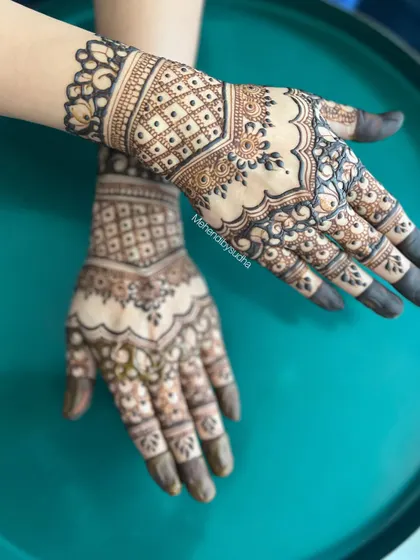 A beautiful short-hand mehendi design. The pattern is contained to the hand and wrist, featuring a check pattern and a delicate border.