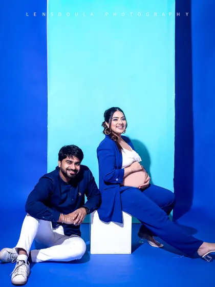Another dynamic pose from the blue-themed shoot, showing the versatility of a simple, colorful backdrop to create different moods.