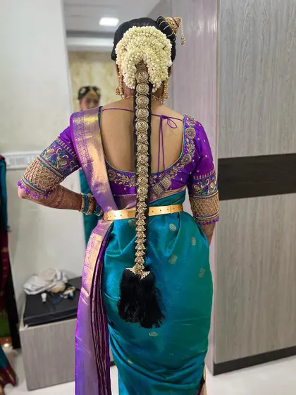 A traditional Iyengar bridal look, complete with the Andal Kondai hairstyle and authentic jewelry. The makeup is kept classic and elegant to honor the cultural details of the ceremony.