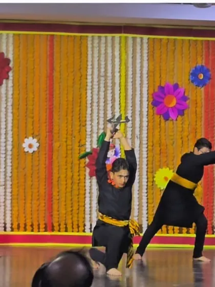 A powerful moment from a school performance, where a student brandishes a prop sword, embodying the warrior spirit of Chhau.