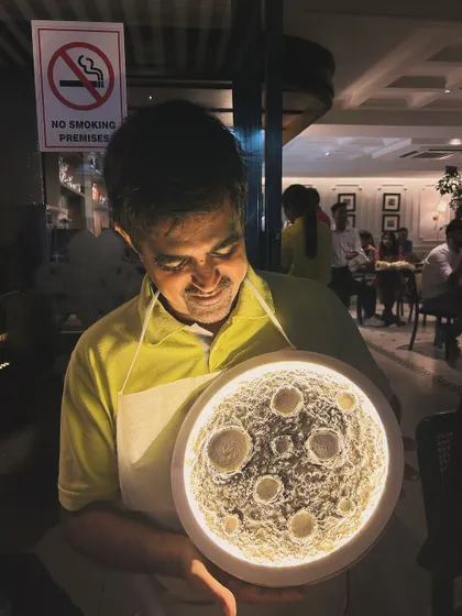 The look of pure joy and pride. This participant is admiring his finished moon lamp, a unique piece of art that he created himself.