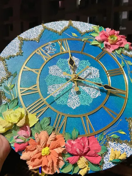 Another angle of the ocean-themed clock, held to show its details in the light.