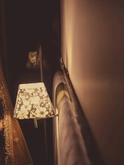 A moody, atmospheric portrait of a bride, using ambient light from a lamp to create a cinematic feel.