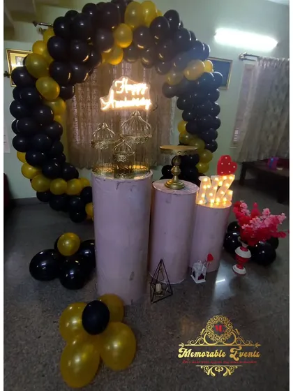 A sophisticated black and gold theme featuring a balloon arch, a gold shimmer backdrop, and a 'Happy Birthday' neon sign.