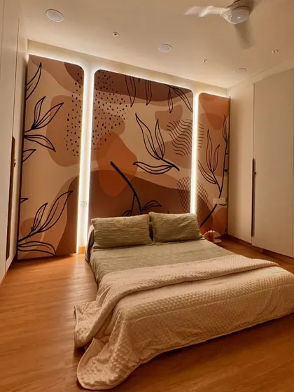 This guest bedroom features a custom-designed, backlit wall mural with abstract botanical patterns. The earthy tones and soft lighting create a warm and welcoming atmosphere, while the low bed adds to the minimalist, grounded feel of the room.
