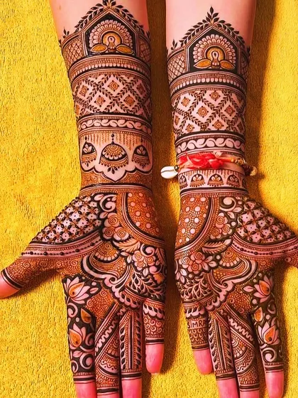 This design is rich with traditional elements, including domes and jhumkas (earrings) on the palms and wrists. The use of bold lines and delicate shading creates a stunning effect, perfect for a bride.