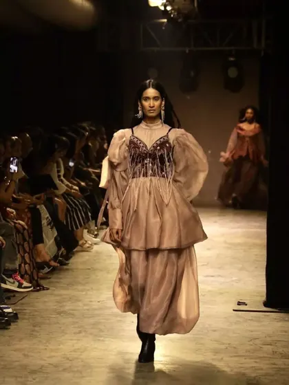 A runway shot from the FAD show. The dewy makeup with draped blush catches the light beautifully as the model walks.
