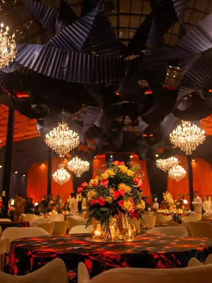 A dramatic and exciting theme for a Diwali poker night. The decor features a bold rustic orange and black color scheme, with industrial-style ceiling installations and grand crystal chandeliers.